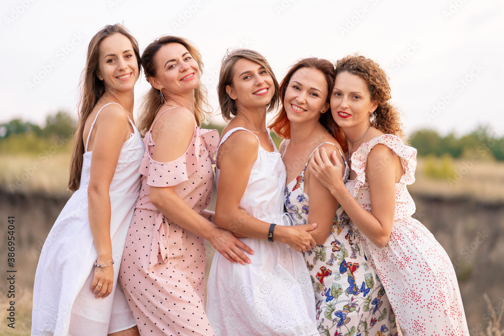 A cheerful company of beautiful girls friends enjoy the company and have fun together in a picturesque place of green hills. A cheerful company of beautiful girls friends enjoy the company and have fun together in a picturesque place of green hills.