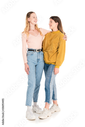 Smiling teenagers embracing and looking at each other on white background