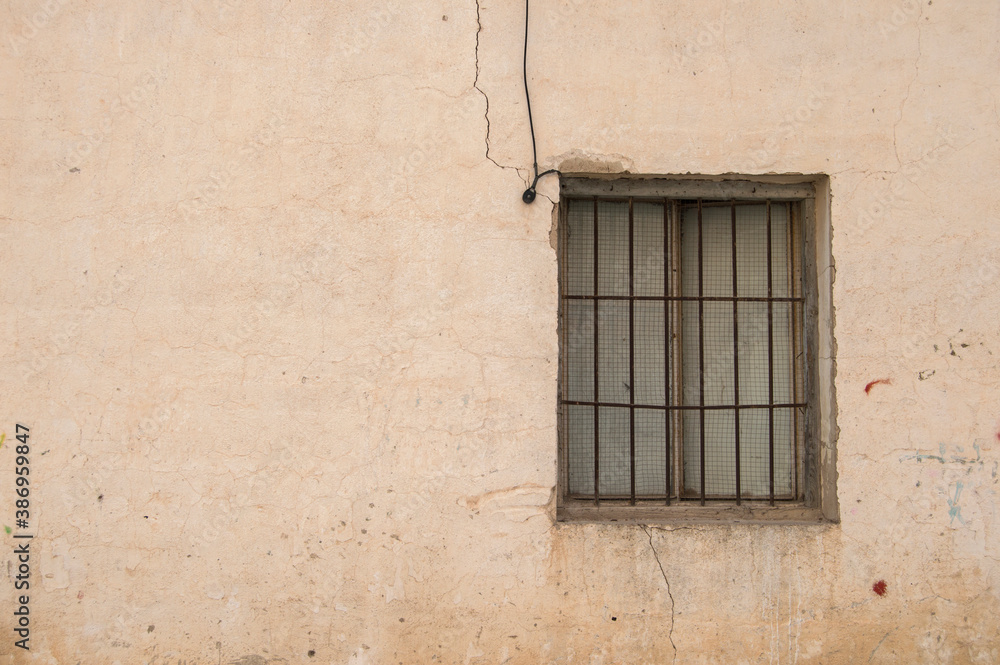 Fototapeta premium old chipped brick facade of a warehouse with a window 