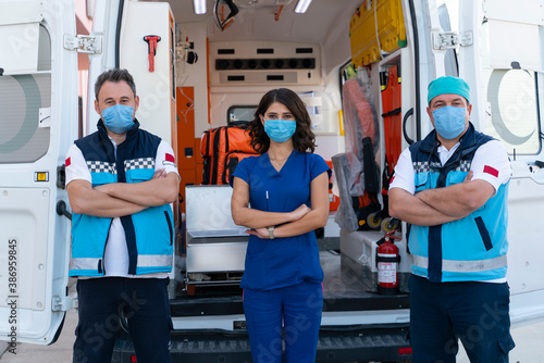 Paramedics working in an ambulance during the COVID-19 pandemics and wearing a face mask photo