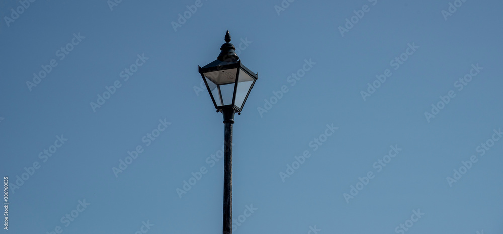 UK. 2020. An old lamp light against a blue sky