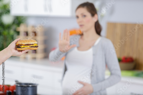 pregnant woman with belly refused to eat a burger