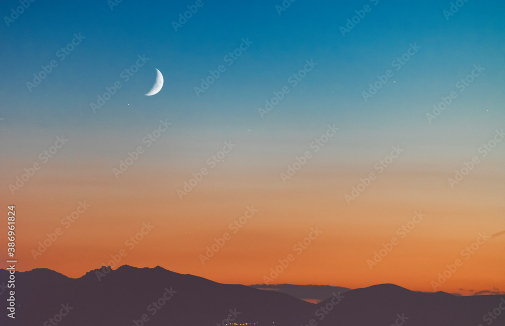 Fototapeta premium Beautiful panoramic view of the mountains with moon on the starry sky.