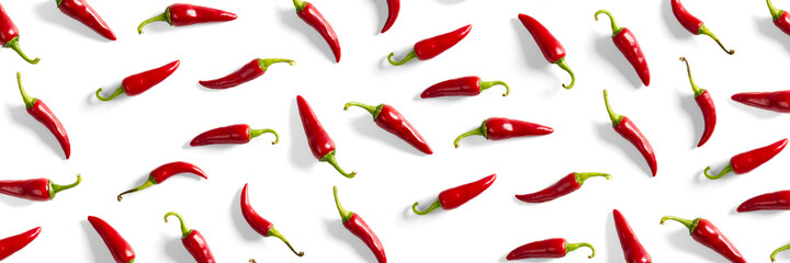Creative background made of red chili or chilli on white backdrop. Minimal food backgroud. Red hot chilli peppers background.
