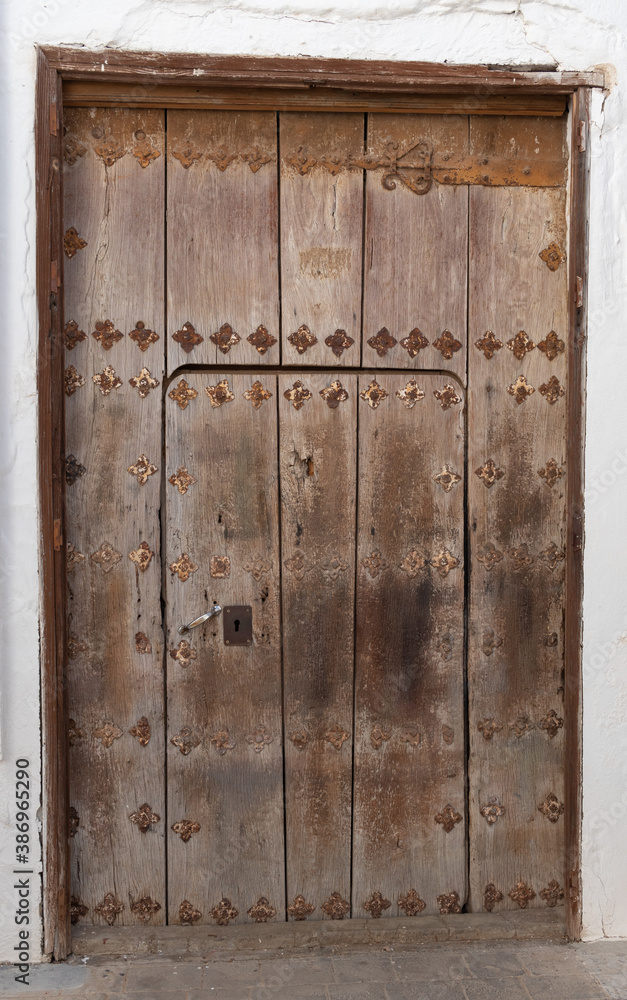 Brown solid door typical of old towns in Spain, very typical of Andalusia.
