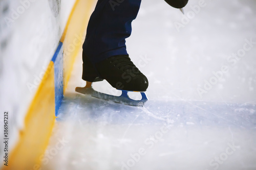 Figure skates legs on ice. Figure skating school. Young figure skaters practicing at indoor skating rink. Kid learning to ice skate.