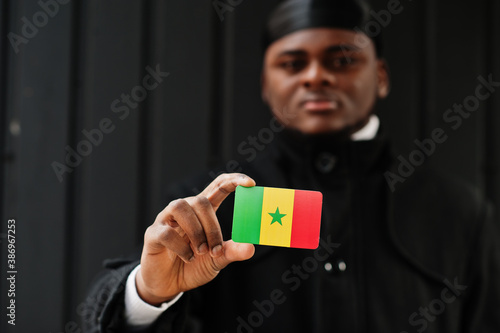 African man wear black durag hold Senegal flag at hand isolated dark background. photo