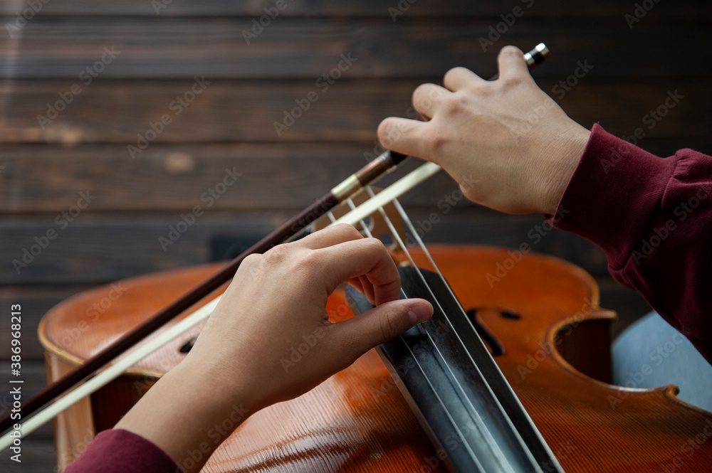 Musician with cello plays the strings with his hands Musician with cello plays the strings with his hands