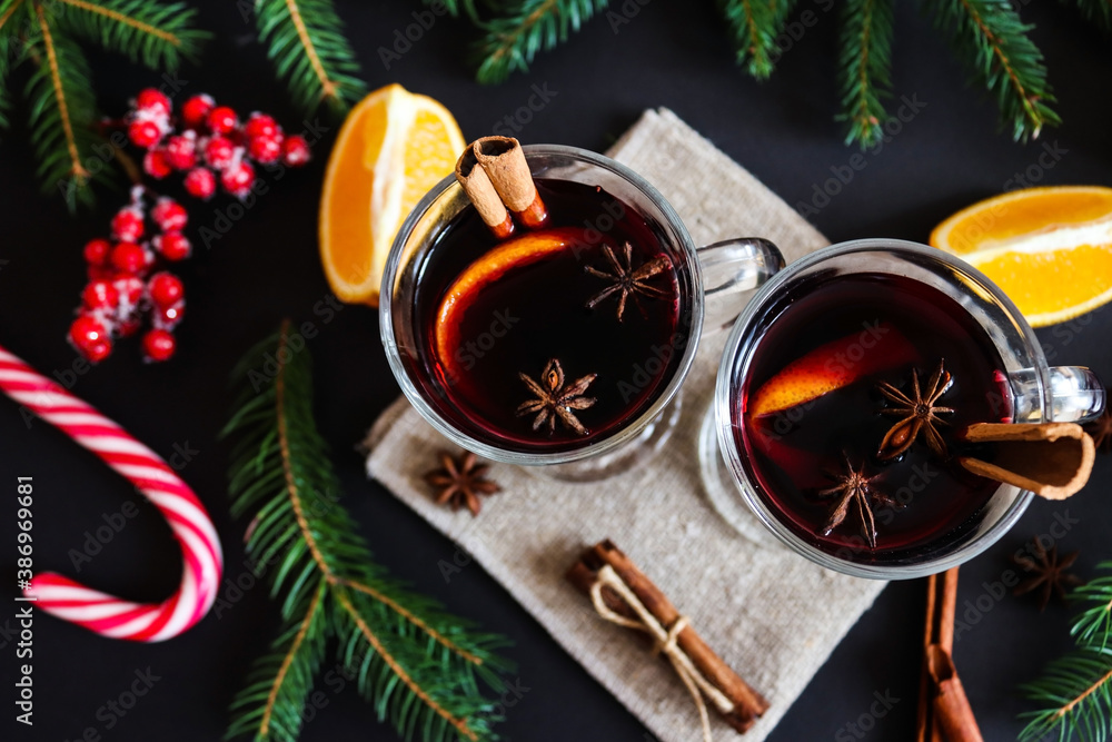 Two glasses of mulled wine with cinnamon and oranges on a festive Christmas background. Christmas drinks, winter concept. Flat lay, top view, close-up Two glasses of mulled wine with cinnamon and oranges on a festive Christmas background. Christmas drinks, winter concept. Flat lay, top view, close-up