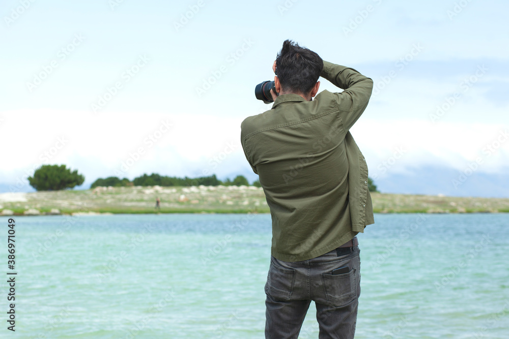 man is photographing the sea