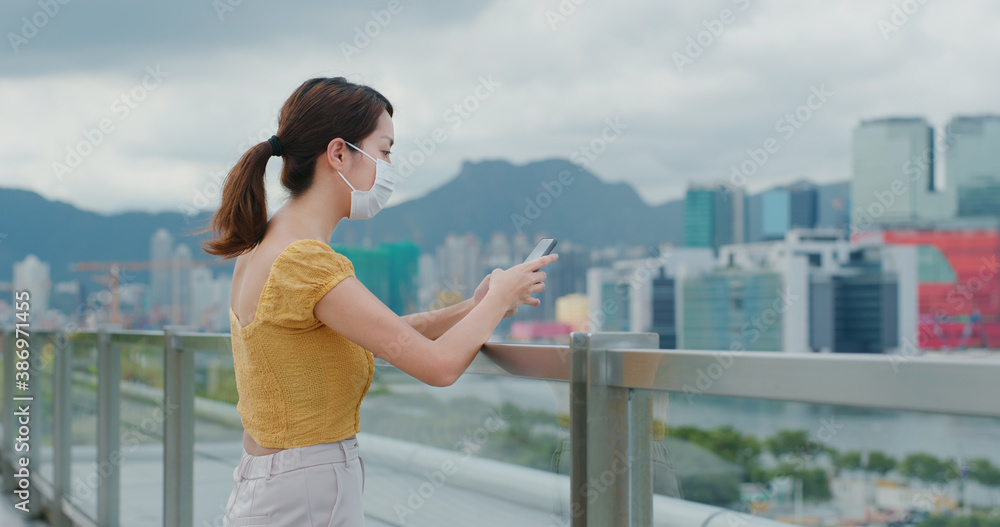 Woman wear face mask and use of mobile phone in city Woman wear face mask and use of mobile phone in city