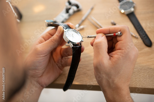 the watchmaker is repairing the mechanical watches in his workshop photo