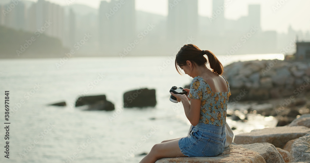 Woman take photo on camera and sit at the seaside Woman take photo on camera and sit at the seaside