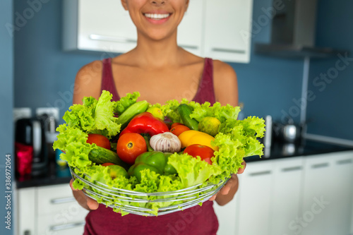 CLOSE UP: woman holding a basket of fresh vegetables in her hands