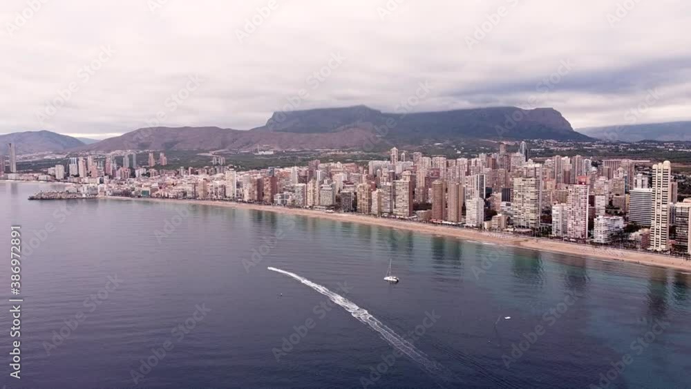 Aerial view of a cloudy seaside city. Daytime skyline of Benidorm, Spain. Panning shot. Aerial view of a cloudy seaside city. Daytime skyline of Benidorm, Spain. Panning shot.