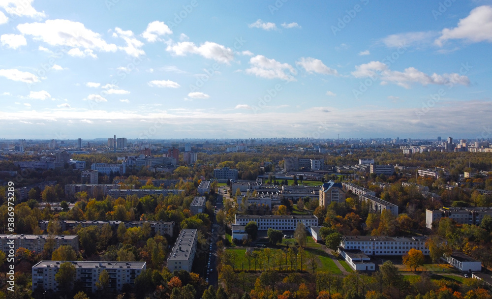 Fototapeta premium Top view of the autumn city with tenement houses and trees