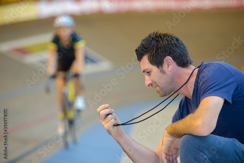 portrait of coach timing cyclist photo