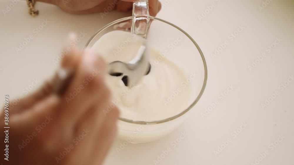 Woman Adding Blueberries To Yoghurt Woman Adding Blueberries To Yoghurt