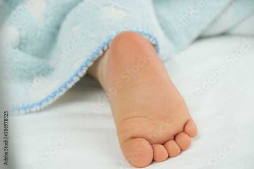 feet sleeping baby sticking out from under the blanket