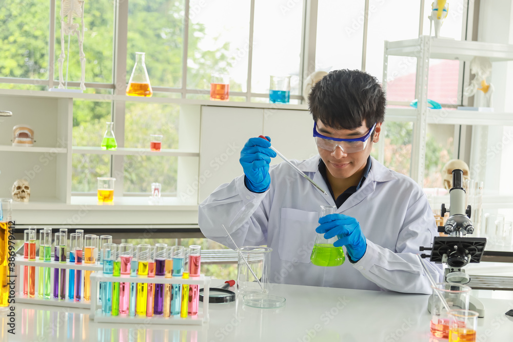 Portrait of young asian professional doctor scientist wearing glasses and blue rubber gloves holding pipette and chemical glass bottle to research in working laboratory. Portrait of young asian professional doctor scientist wearing glasses and blue rubber gloves holding pipette and chemical glass bottle to research in working laboratory.