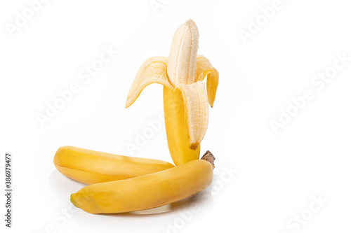 Shooting in the studio. A branch of ripe yellow bananas in a peel. On white background. Close-up.