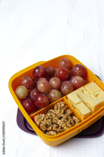 Food in Plastic containers ready to eat with Cheese, grapes and nuts