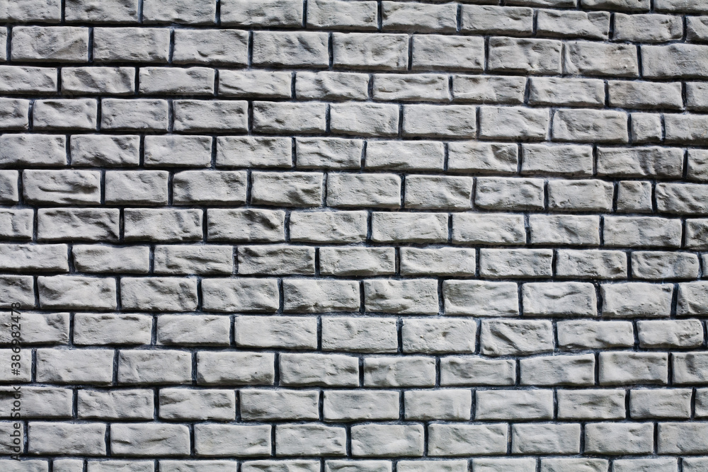 Naklejka premium Texture of a stone grey wall. Part of a building wall. Close-up.