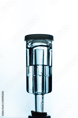 Glass fermentation tube in a bottle of home made wine with bubbles moving during fermenting process. Concept of brewery, craft beer and wine making. Closeup on white background. photo