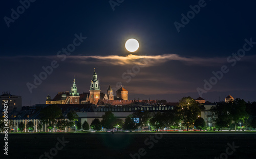 Wawel Castle and full moon, Krakow, Poland, seen from Blonia meadow.