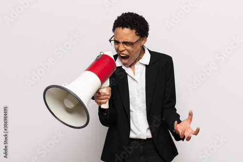 Tableau sur toile young black afro woman looking angry, annoyed and frustrated screaming wtf or wh