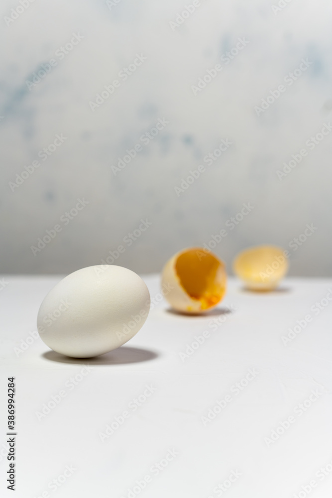 One healthy egg in the foreground and broken egg at background. Conceptual image with copy space. One healthy egg in the foreground and broken egg at background. Conceptual image with copy space.