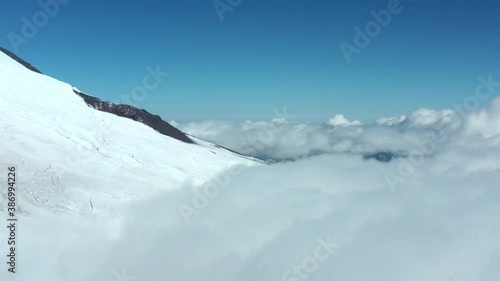 Garabashi tourist station with different buildings shelters barrels and assault camps base mes on snowy slope of picturesque old Elbrus mountain on cold day aerial view. photo