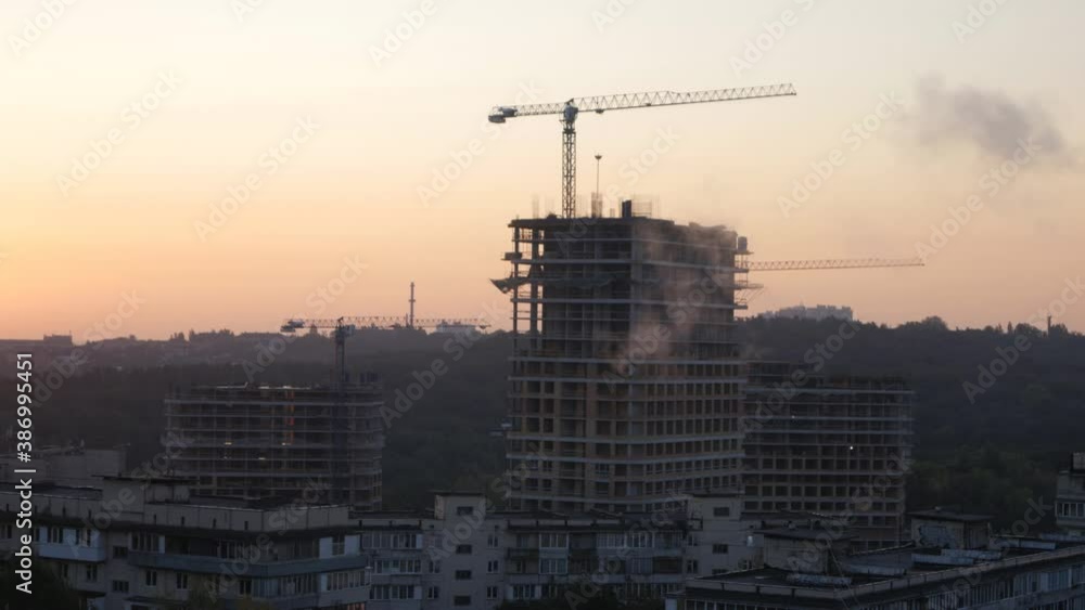 Construction cranes are erecting the walls of new buildings Construction cranes are erecting the walls of new buildings