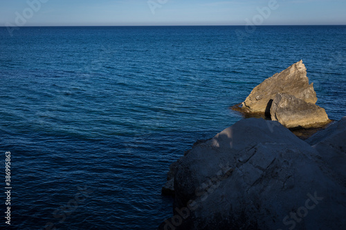 Horizontal rocky seascape of blue ocean water until the horizon of the Alboran Sea, Andalusia's largest coastal protected area, Cabo de Gata-Níjar Natural Park in the southeastern corner of Spain