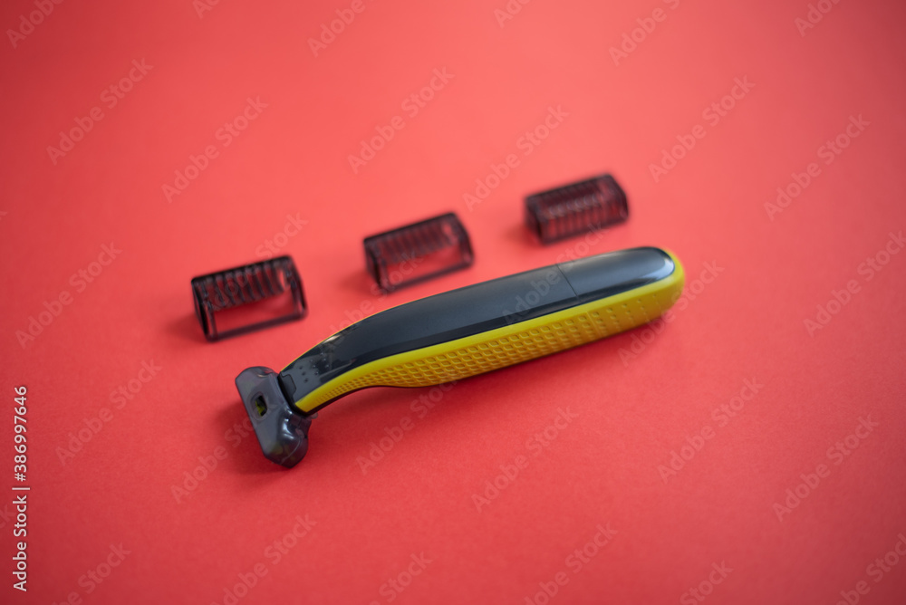 Beard trimmer with three attachments on the red background. Beard trimmer with three attachments on the red background.