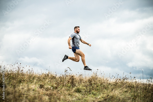 handsome trail runner running in nature