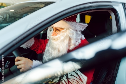 Authentic Santa Claus driving his modern car, outdoors © Serhii