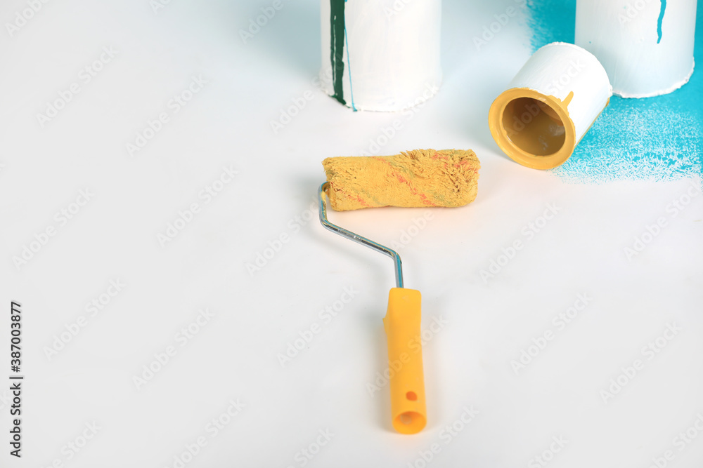 Obraz premium Instruments for renovation apartment room isolated on white and blue background. accessories for gluing, painting tools. Colorful paint cans. Concept of repair home. Copy space for advertisement