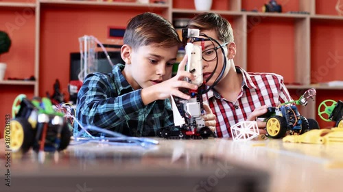 Wallpaper Mural Portrait of two children playing with cars in robotics class. Cute boys call each other and show their machines. Torontodigital.ca