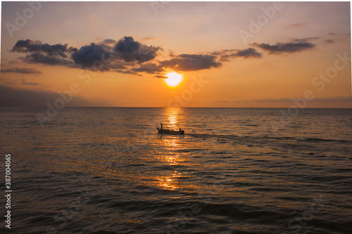 sunset over the sea and a fisherman