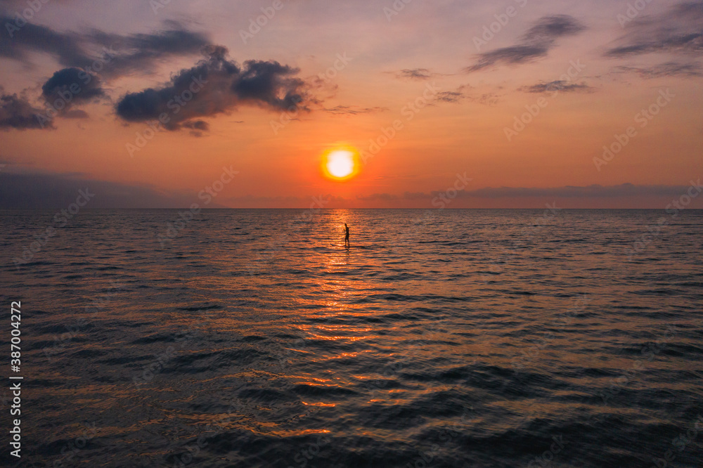sunset over the sea with and paddle board