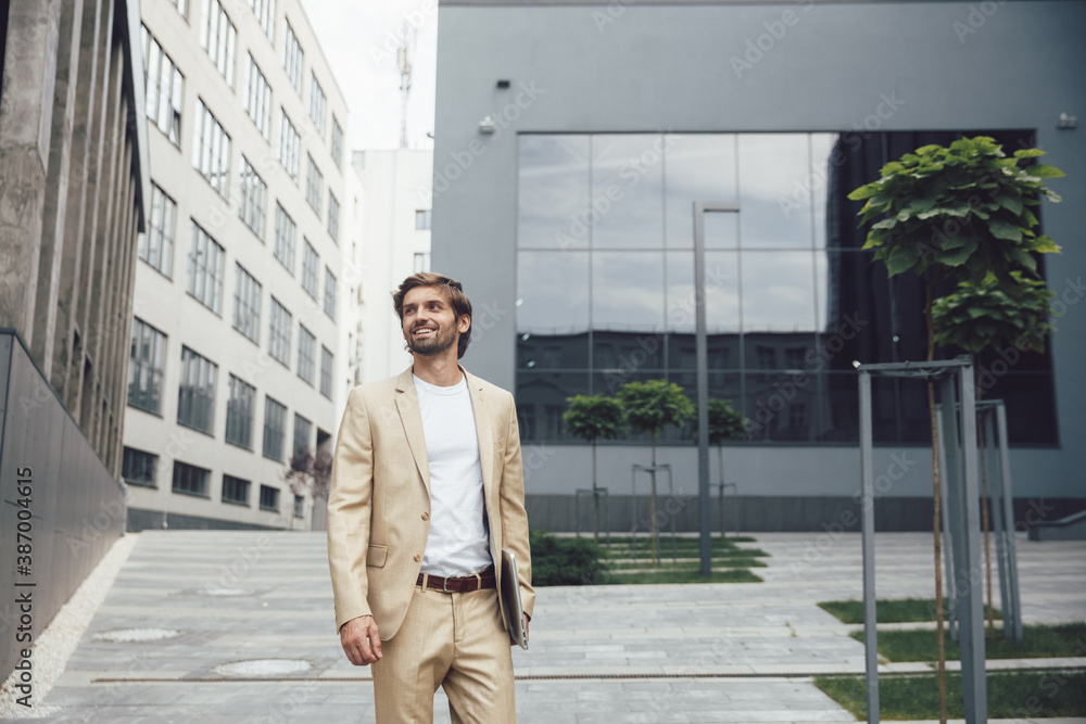 Smiling businessman holding wireless laptop on fresh air Smiling businessman holding wireless laptop on fresh air