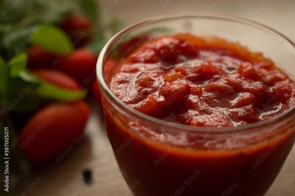 Close up of Neapolitan tradition tomato sauce for pasta or pizza in a glass bowl on a wooden background. Cooked with tomatoes, peppers, oil, garlic, tomato paste, oregano, onions and basil. Close up of Neapolitan tradition tomato sauce for pasta or pizza in a glass bowl on a wooden background. Cooked with tomatoes, peppers, oil, garlic, tomato paste, oregano, onions and basil.