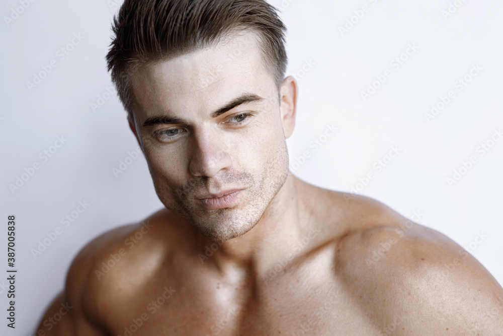 Muscular sexy model sports young man on white background. Portrait of beautiful smiling healthy guy.