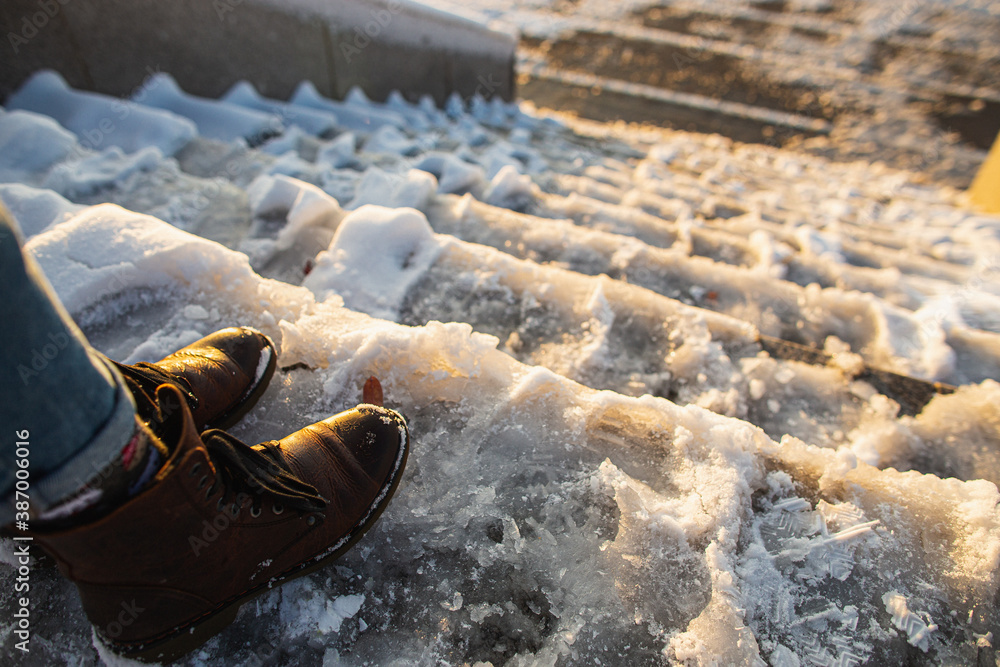 © Northern life - Danger of slipping. Female boots on rough slipper ice surface. A woman in brown leather shoes descends the slippery ice ladder. © Northern life - Danger of slipping. Female boots on rough slipper ice surface. A woman in brown leather shoes descends the slippery ice ladder.