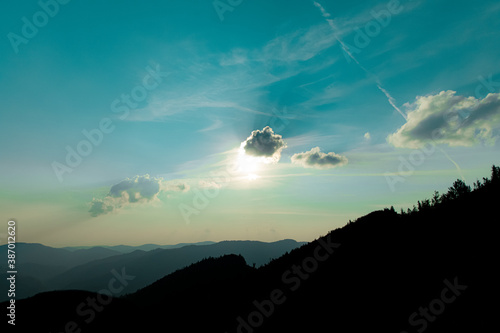 wallpaper mountain landscape evening blue sky and sun light behind cloud black abstract ridge silhouette and empty copy space for your text