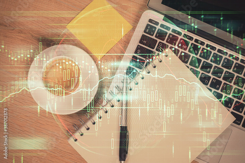 Double exposure of forex chart drawing over table background with computer. Concept of financial research and analysis. Top view.