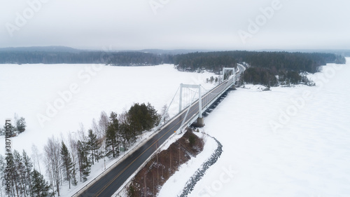 Aerial top view of bridge road above frozen lake in snow winter Finland. © raland