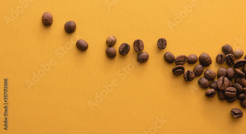 Coffee beans on yellow background. Top view with copy space for text