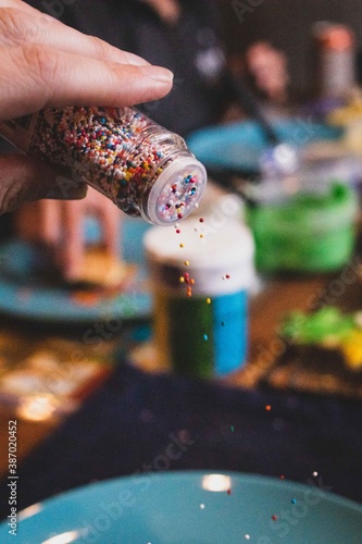 Color decorative sugar sprinkles falling from the bottle